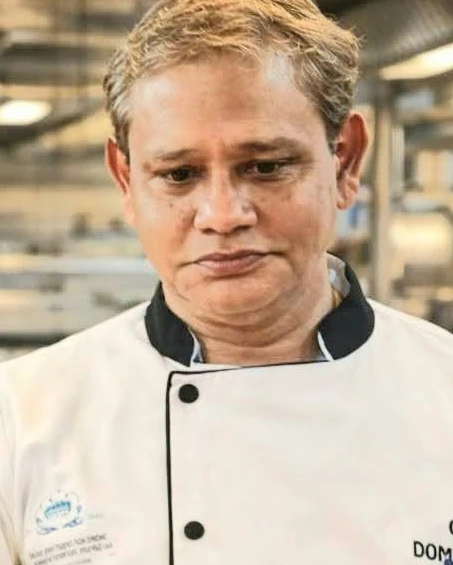 Chef Dominic Gomes in chef whites in a professional kitchen