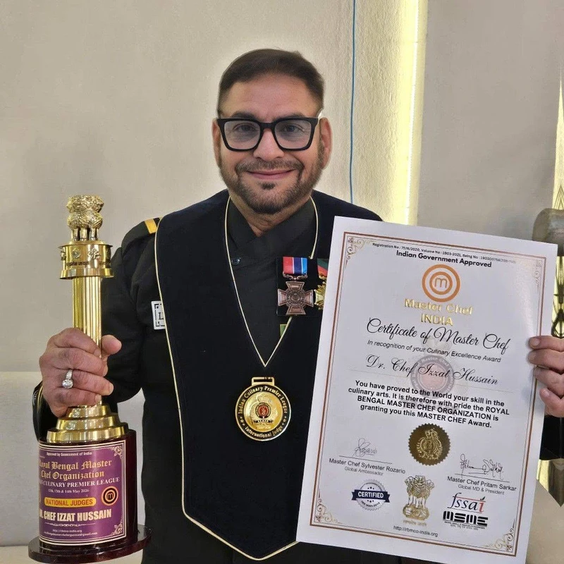 Chef Dr Izzat Husain holding his Master Chef certificate and trophy